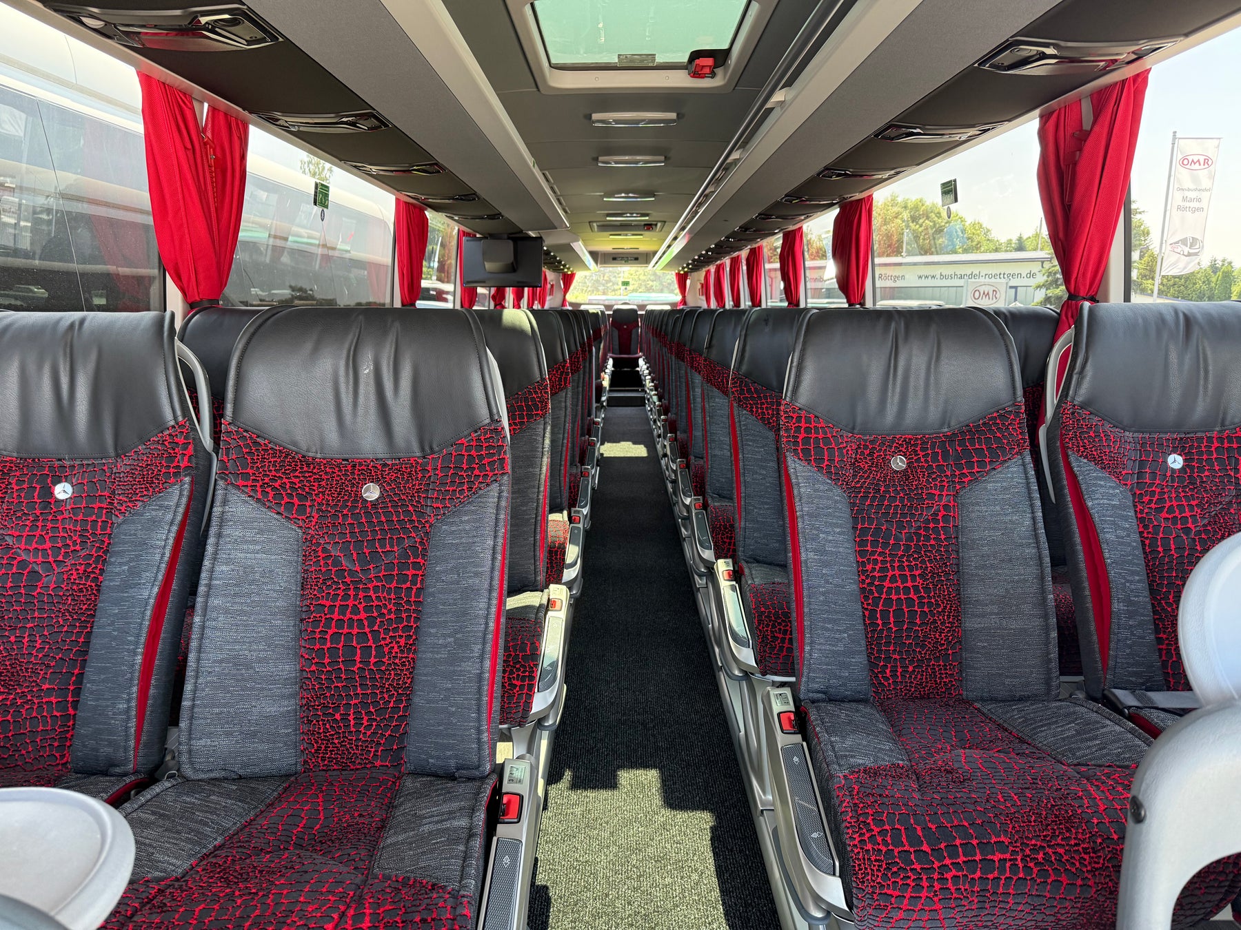 Intérieur d’un autocar Moreira Voyages, sièges noirs et rouges